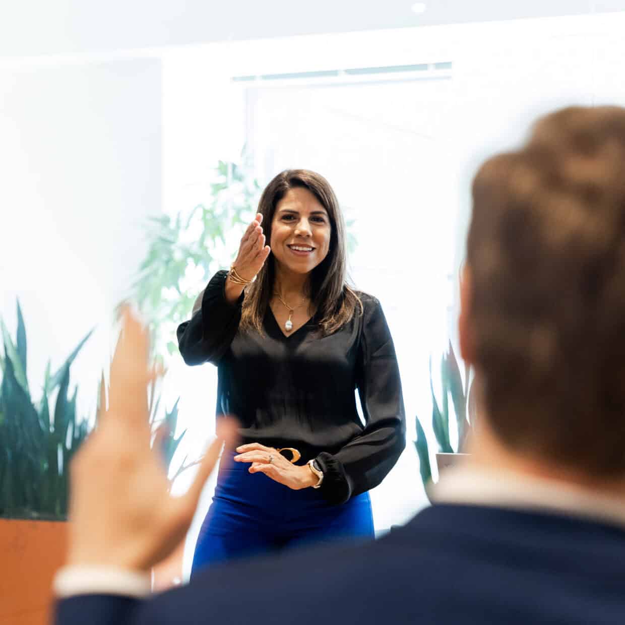 Woman leading a development training program while people raise hands