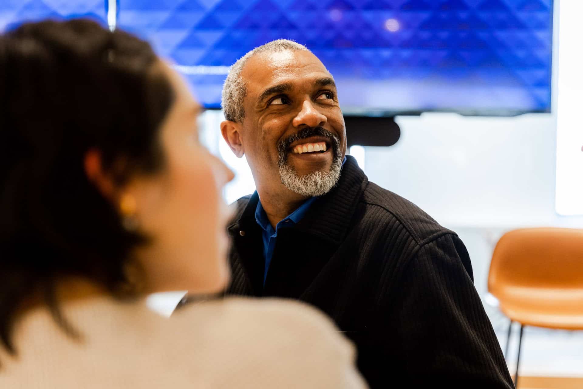 Mature black man and young white woman happily discussing technology talent development