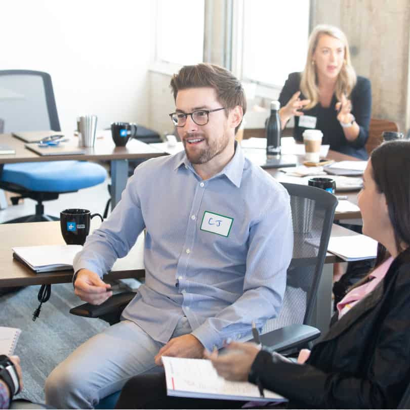 Young white man with glasses happily discussing a development training program