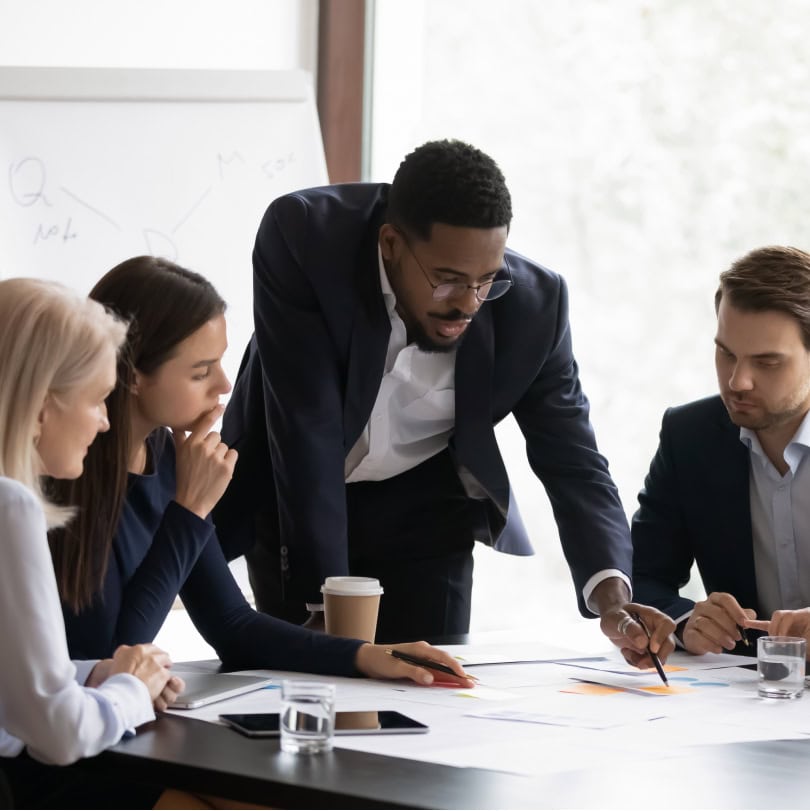Diverse coworkers looking over papers about sales enablement training