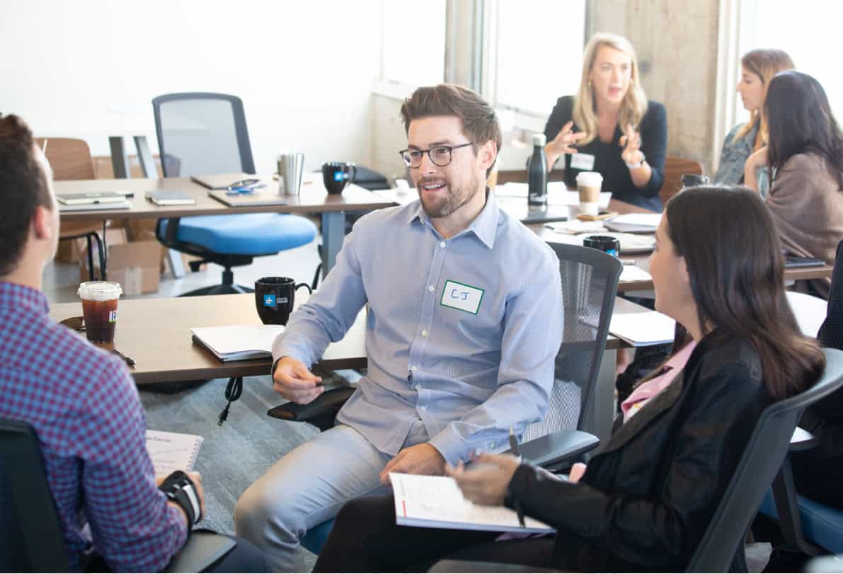 Coworkers happily conversing during a group coaching event