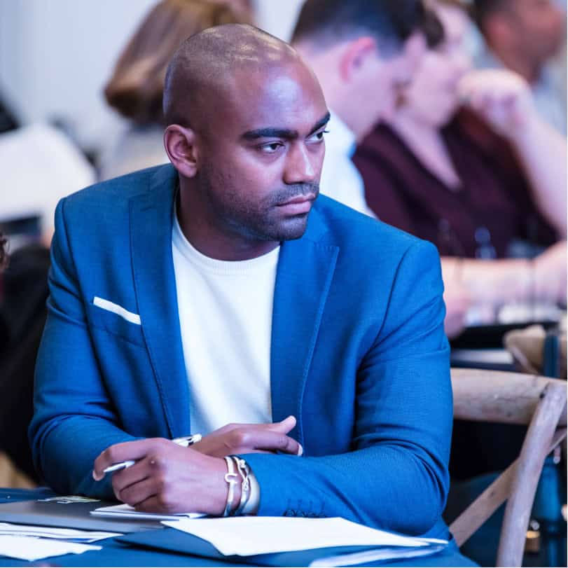 Professional bald man in a blazer taking notes on sales team development strategy