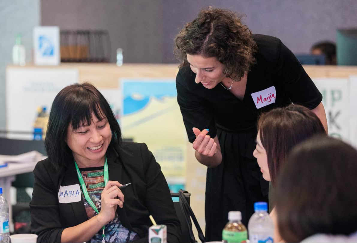 Woman happily coaching women on employee engagement statistics