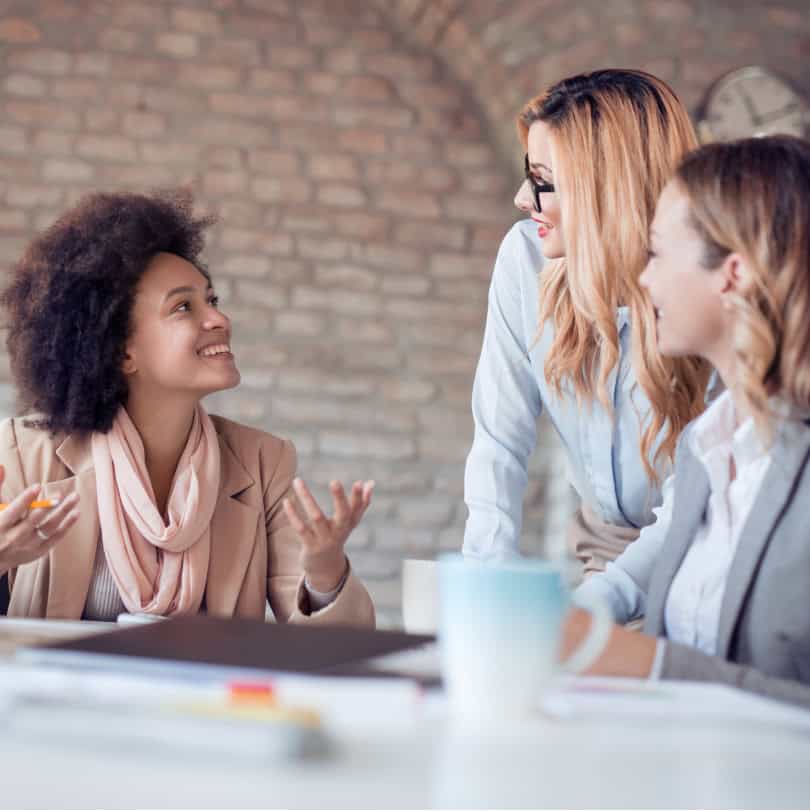 Group of diverse women conversing during womens leadership training with coffee