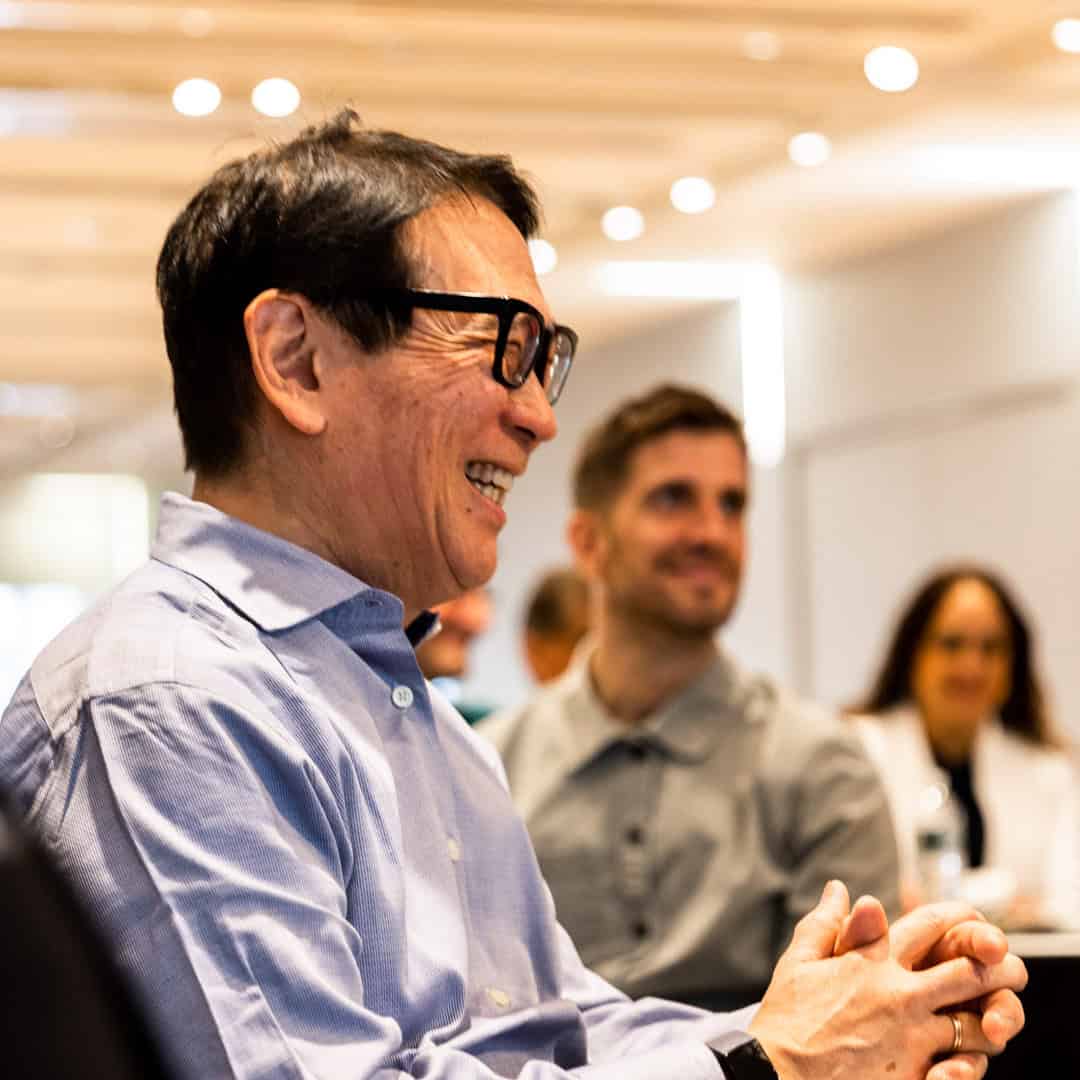 Portrait of a man smiling with coworkers while discussing employee engagement statistics