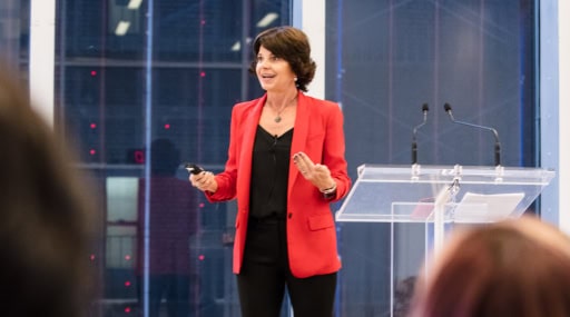 Woman in a red blazer discussing motivational speakers