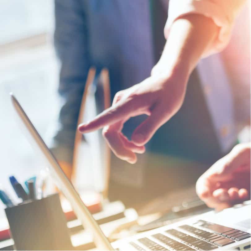 Woman pointing at a laptop to discuss professional development for marketing