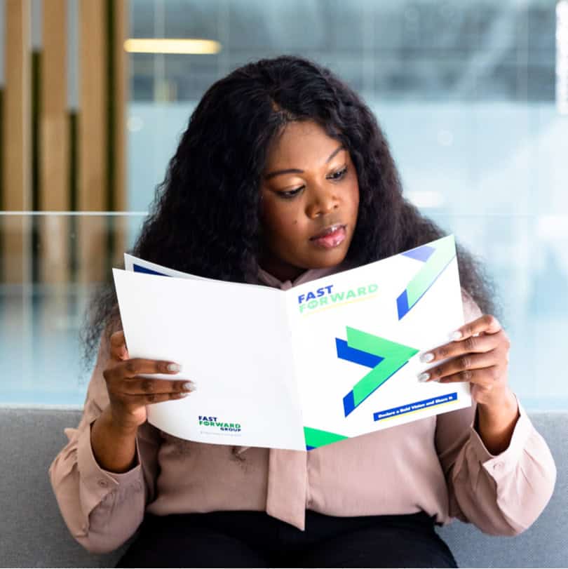 Young black woman looking at workplace diversity training handbook