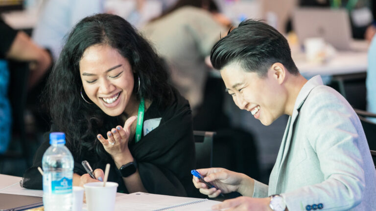 Two women smiling and discussing how to support women in the workplace